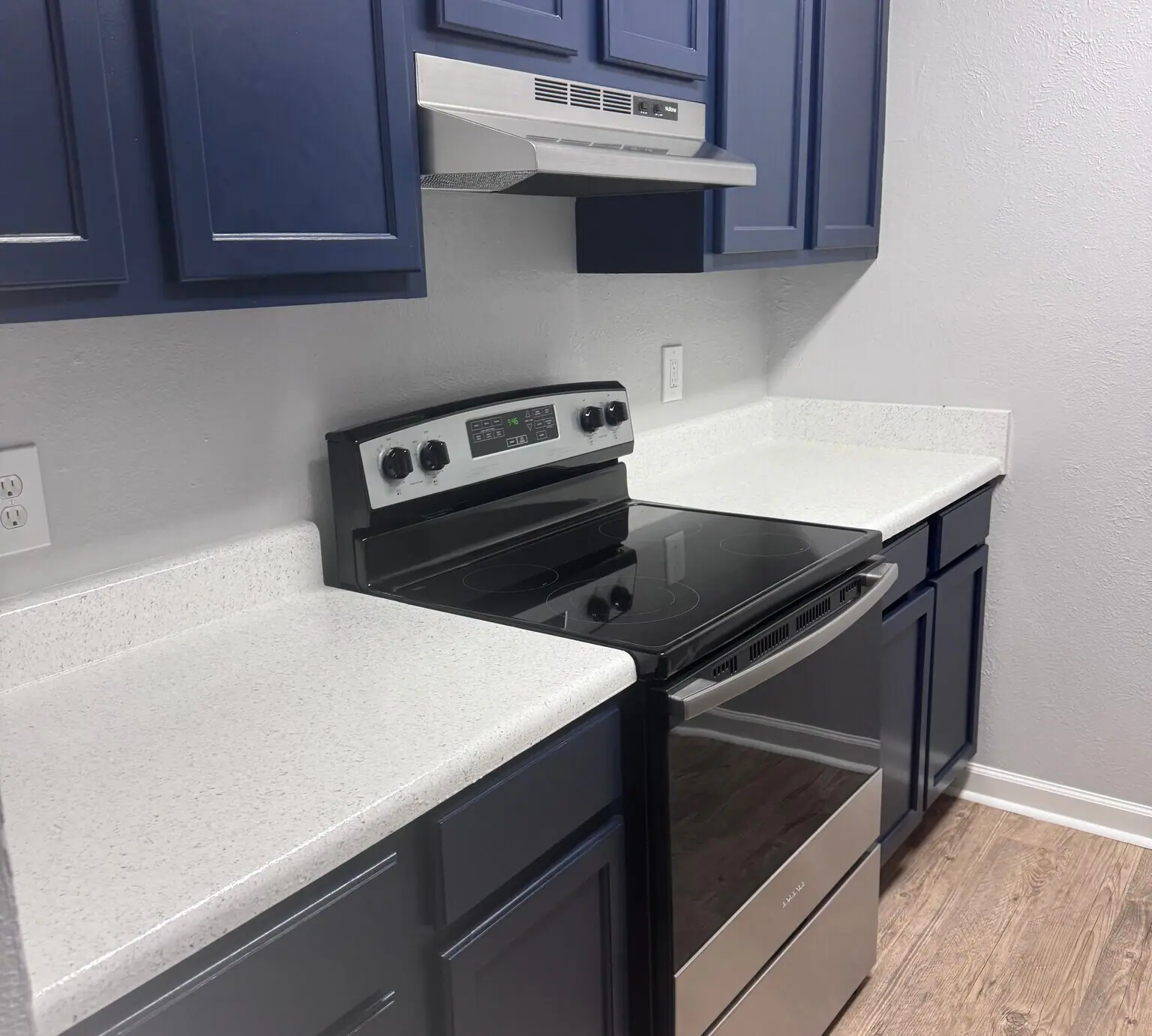 Cypress Cove apartment kitchen with navy cabinets built by Empowered Services